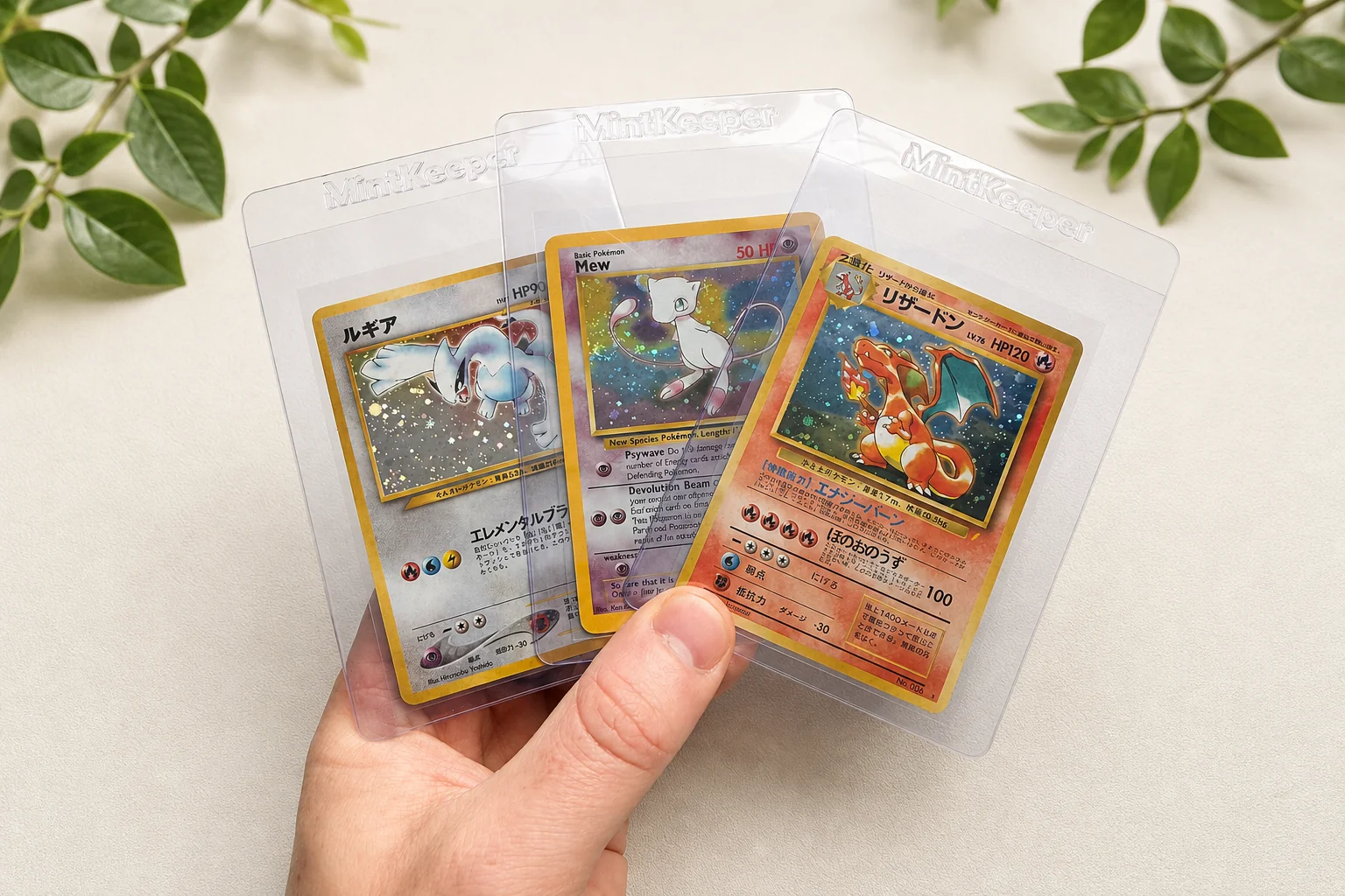 Three Pokémon trading cards in protective sleeves at the Kodap Cleans card cleaning and restoration studio