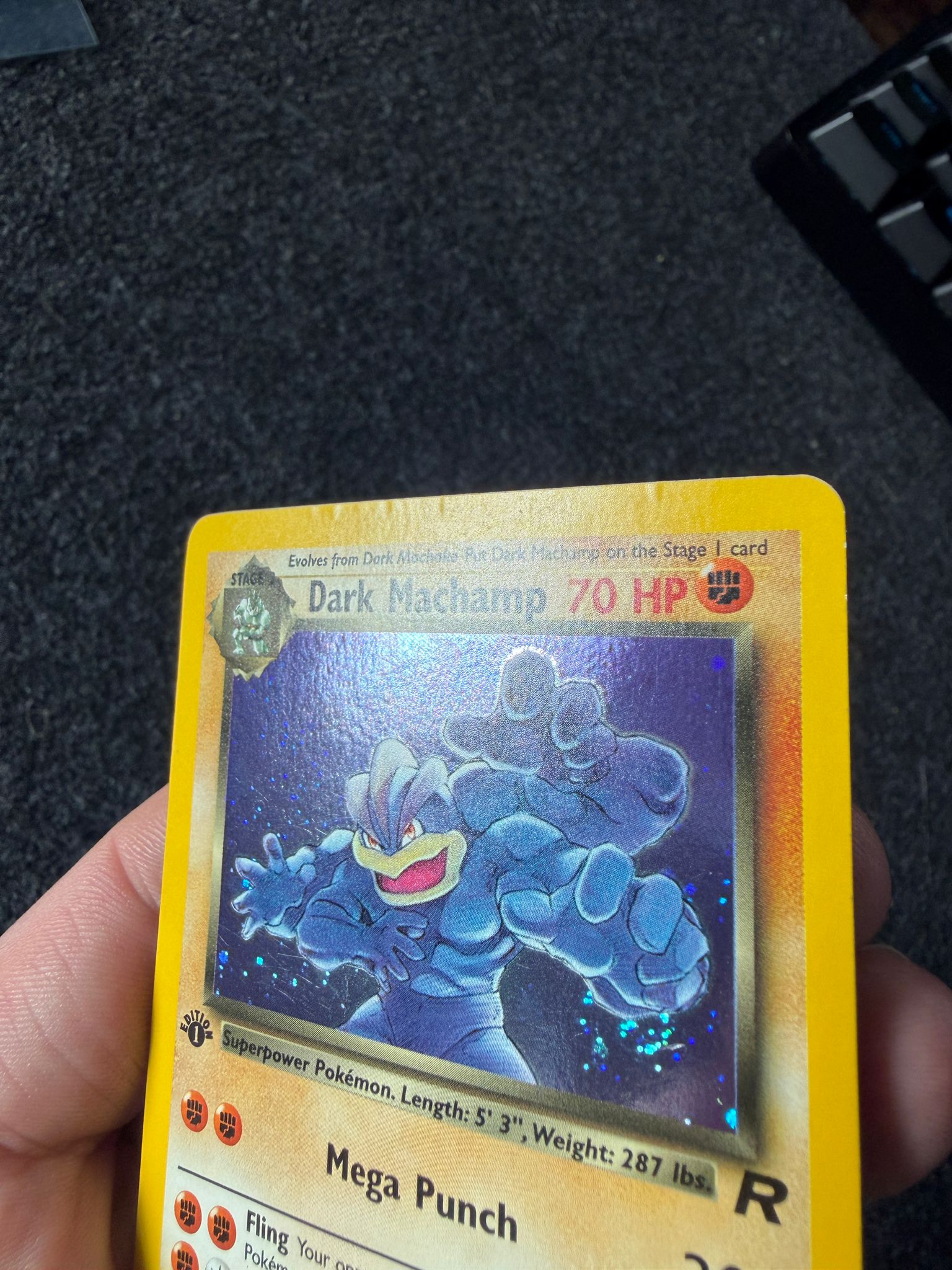 Dark Machamp Pokémon trading card before restoration, with creasing visible along the top edge