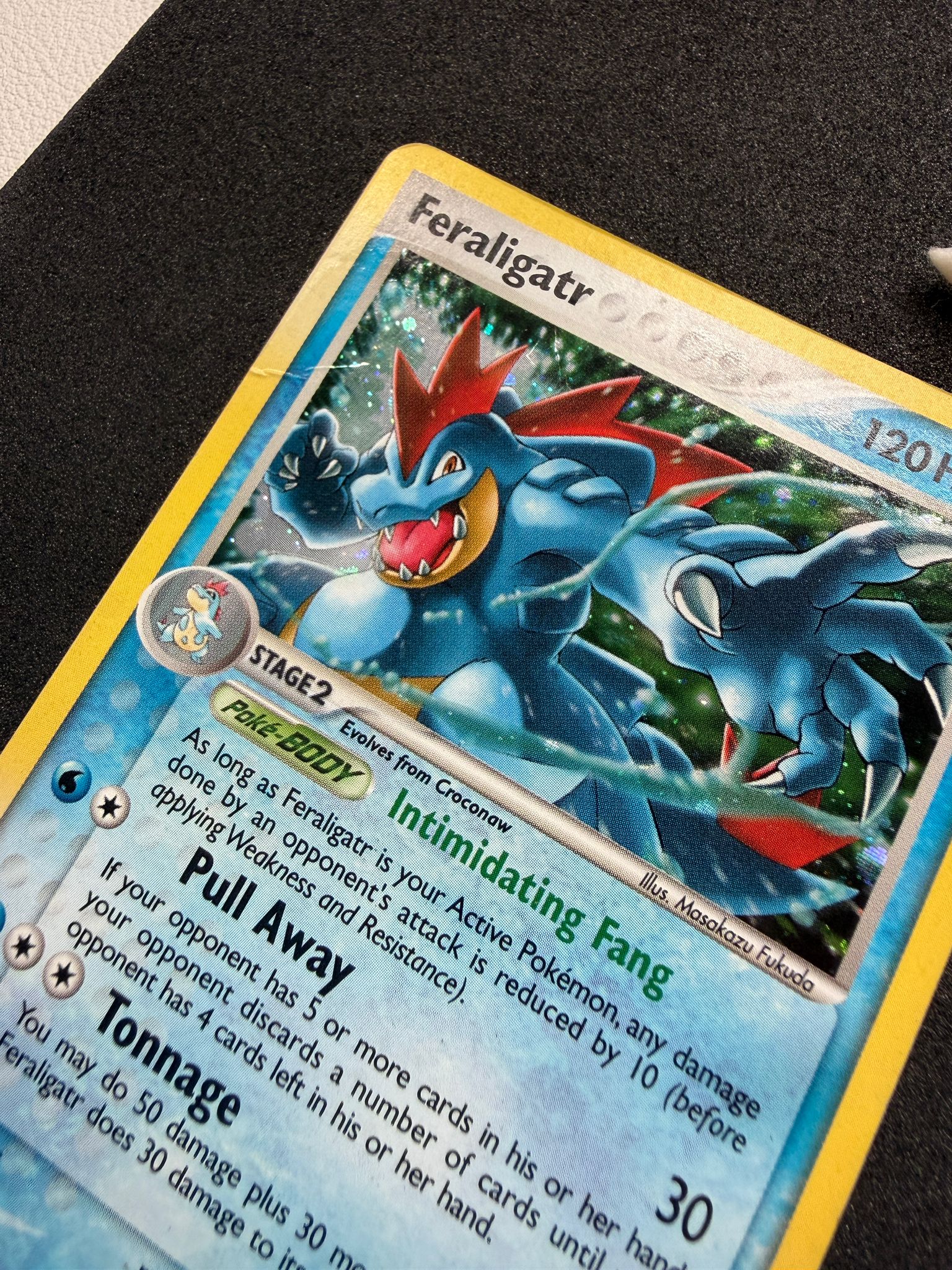 Feraligatr Pokémon trading card before restoration, with a crease visible along the left edge